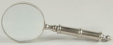 A MAGNIFYING GLASS with chrome handle.