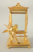 A GOOD GILT BRONZE CUPID before a mirror. 9ins high.