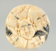 A CARVED BONE FACES NETSUKE. 3.5cm.