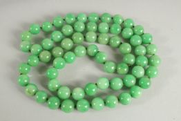 A LARGE STRING OF JADE BEADS. 34ins long.