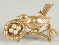 A SMALL 9CT GOLD AND PEARL BIRD, WITH A NEST BROOCH.