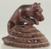 A CARVED WOOD BEAR on a lily pad. Signed.