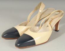 A PAIR OF CHANEL CREAM AND NAVY SHOES. Size 40 in Chanel dust bags.