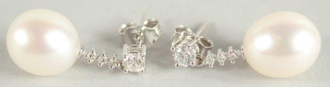 A PAIR OF 18 CARAT WHITE GOLD, PEARL AND DIAMOND DROP EARRINGS. Diamond 0.52 carat.