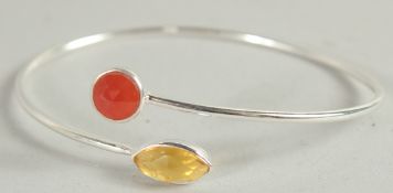 A SILVER BANGLE set with two stones.