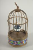 A SMALL CLOISONNE SINGING BIRD in a cage. 7ins high.
