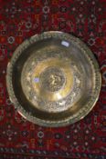 An Eastern brass dish, with engraved decoration.
