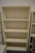 A white lacquer floor standing open bookcase or room divider.