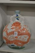 A Chinese moon flask decorated with a dragon.