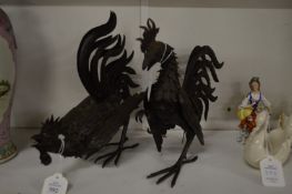 A pair of stylish metal cockerels.