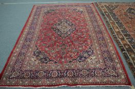 A Persian design carpet, red ground with floral decoration 290cm x 200cm.