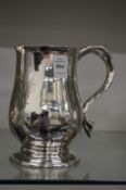 A large silver tankard engraved with an armorial (hole to the body).