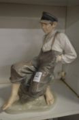 A large Royal Copenhagen figure of a fisher boy seated on a rock model no:1659.