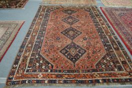 A Persian carpet, pink ground with all over geometric design 320cm x 215cm.