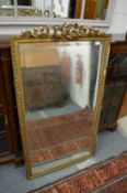 A gilt framed mirror with ribbon and bow cresting.