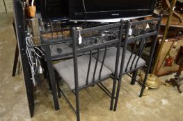 A stylish glass dining table with metal base and four matching chairs.
