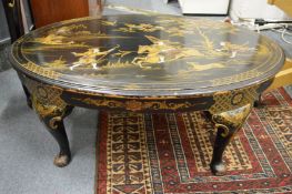A chinoiserie decorated black lacquer oval coffee table.