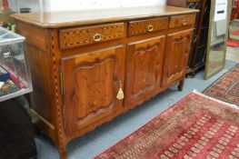 A good French fruit wood sideboard with inlaid decoration comprising three frieze drawers above
