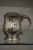 A silver lidded tankard engraved with presentation inscription and numerous recipients names.