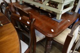 A Victorian walnut extending dining table with one leaf.