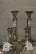 Two pairs of silver candlesticks.