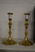 A pair of Georgian style petal base brass candlesticks.