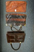 A ladies tan leather clutch bag and two alligator handbags.