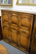 A good oak cupboard with an arrangement of six panelled cupboard doors and three drawers.