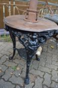 A cast iron and teak circular pub table.