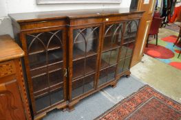 A George III style mahogany breakfront low four door glazed bookcase.