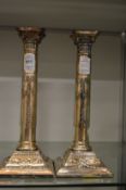 A pair of plated classical column style candlesticks.