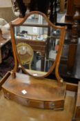 A mahogany dressing table mirror with shield shaped mirror and three drawers to the bow fronted