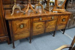 A George III mahogany sideboard with a central drawer above two panel doors flanked by two deep