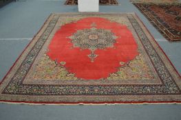 A large Persian design carpet, red ground with floral decoration 360cm x 273cm.