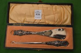 A cased silver handled shoe horn and button hook set.