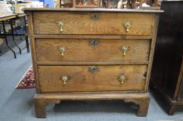 An 18th century Continental oak straight front chest of three graduated long drawers on bracket