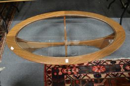 A teak oval glass top coffee table.