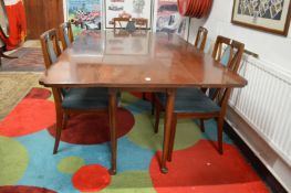 A long narrow walnut drop leaf dining table.