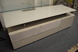 A stylish glass top and cream lacquer large TV stand.