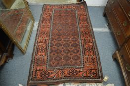 A Persian rug, rust ground with stylised decoration 180cm x 100cm.