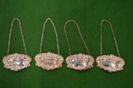 A set of four silver decanter labels.