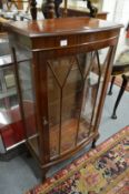 A mahogany bow front display cabinet.