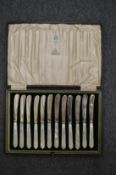 A cased set of twelve silver and mother of pearl handled butter knives, a cased set of six plated