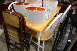 A hardwood rectangular kitchen table with painted base together with four matching chairs.