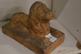 A small reconstituted stone model of a recumbent lion.