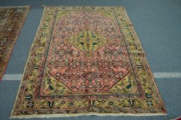 A Persian carpet, pink ground with stylised decoration 215cm x 160cm.