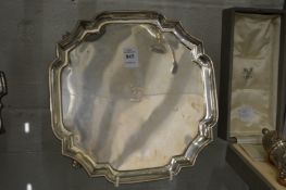 A good silver salver of shaped square outline with moulded border on four scroll feet, the centre
