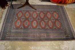 A modern Bokhara style rug 190cm x 125cm.