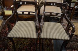A pair of Regency style mahogany chairs with arms.