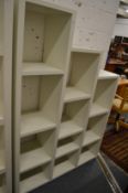 A floor standing white lacquer stepped design cube form open display unit.